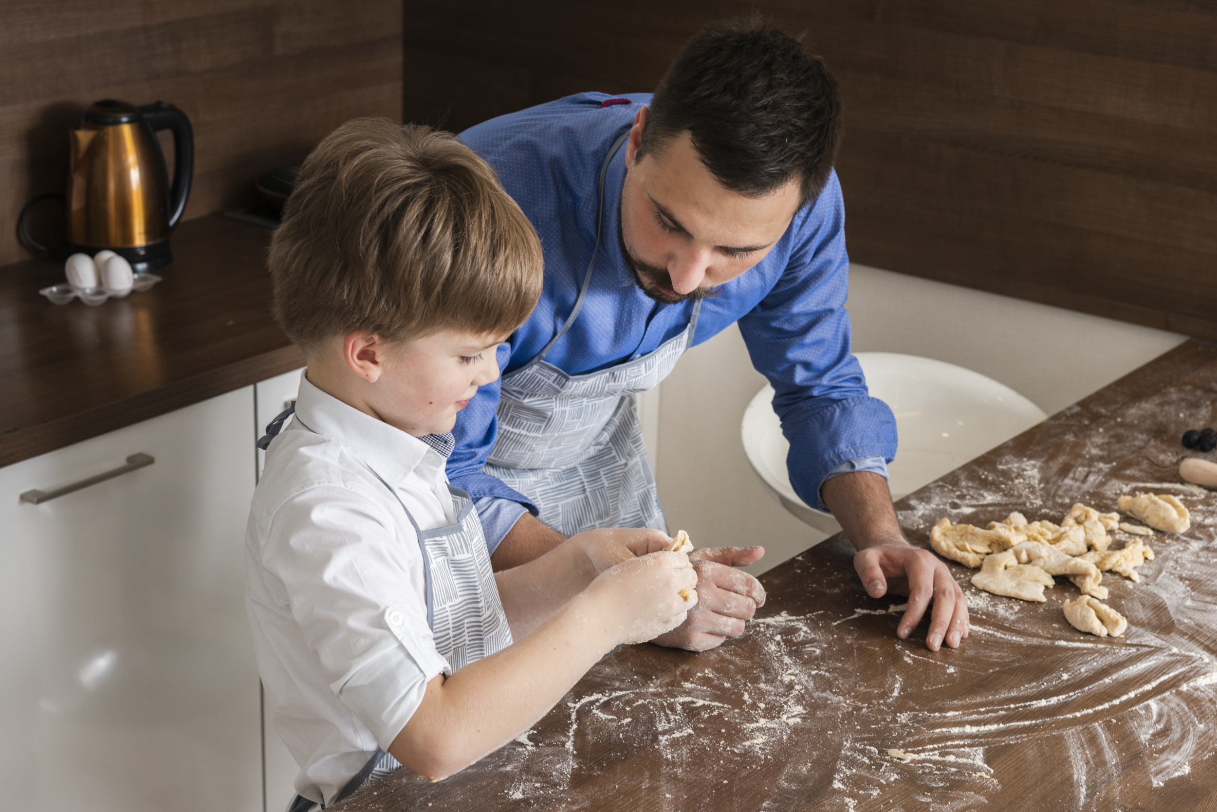 high-angle-father-son-making-shapes-dough.jpg