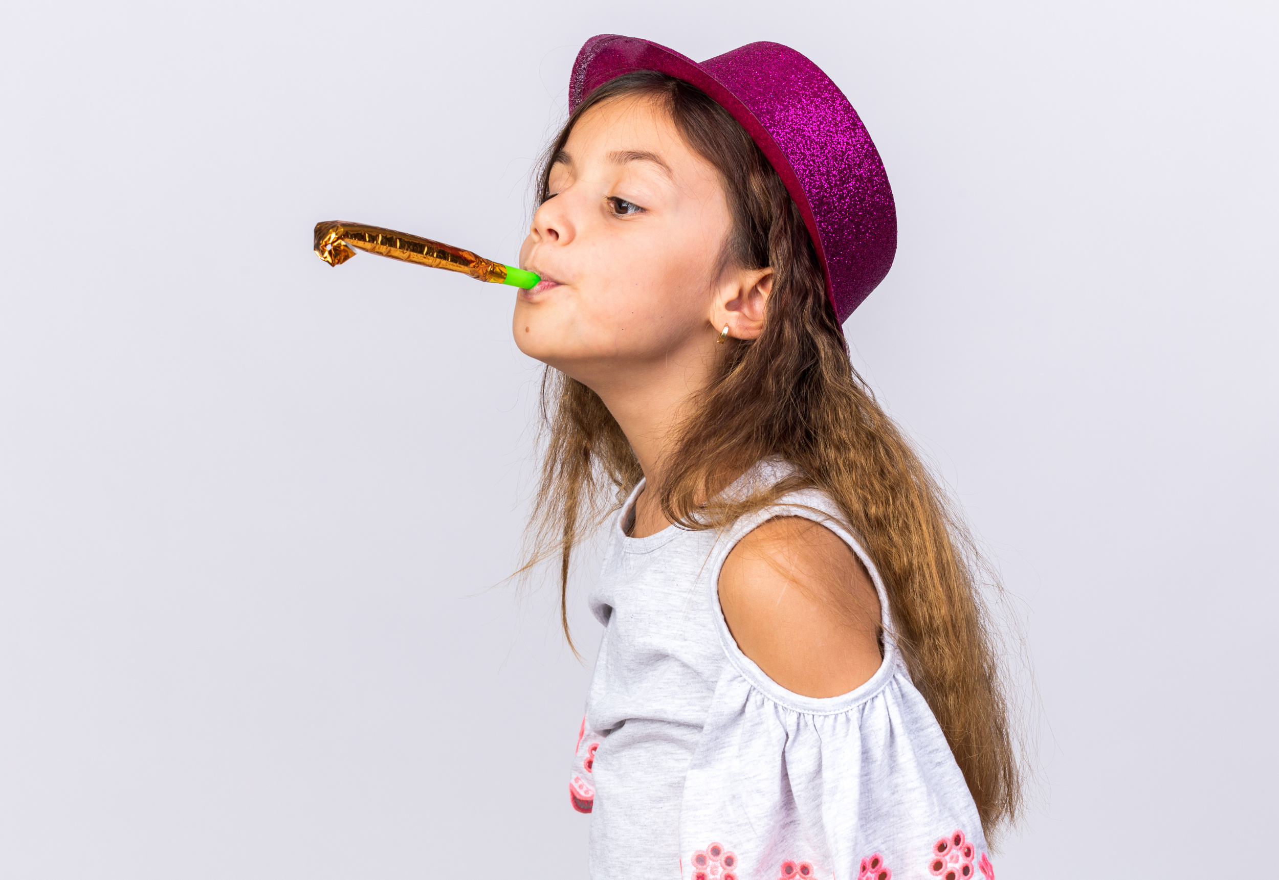 pleased-little-caucasian-girl-with-purple-party-hat-blowing-party-whistle-looking-at-side-isolated-on-white-wall-with-copy-space.jpg
