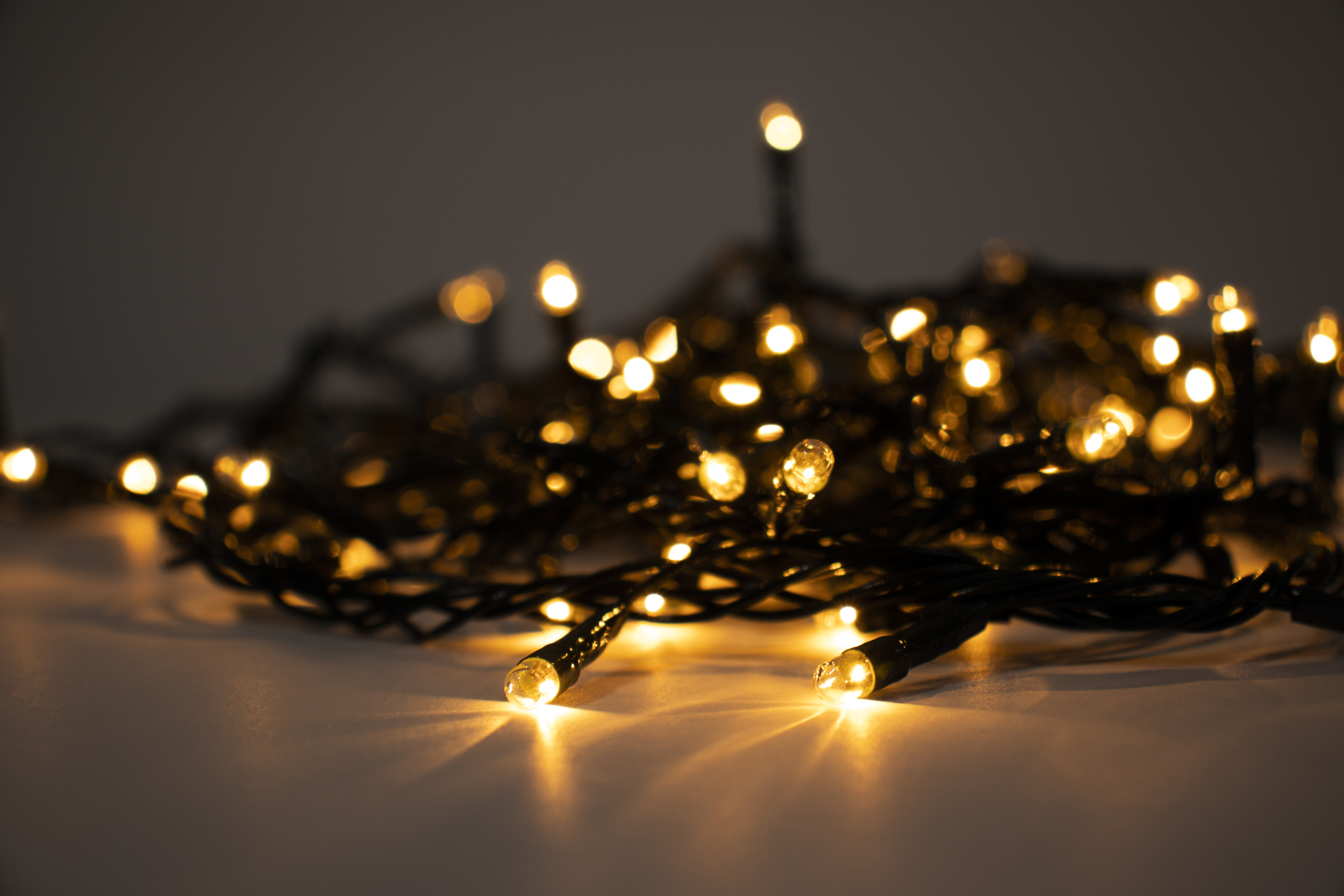 1 closeup-shot-christmas-lights-white-surface.jpg