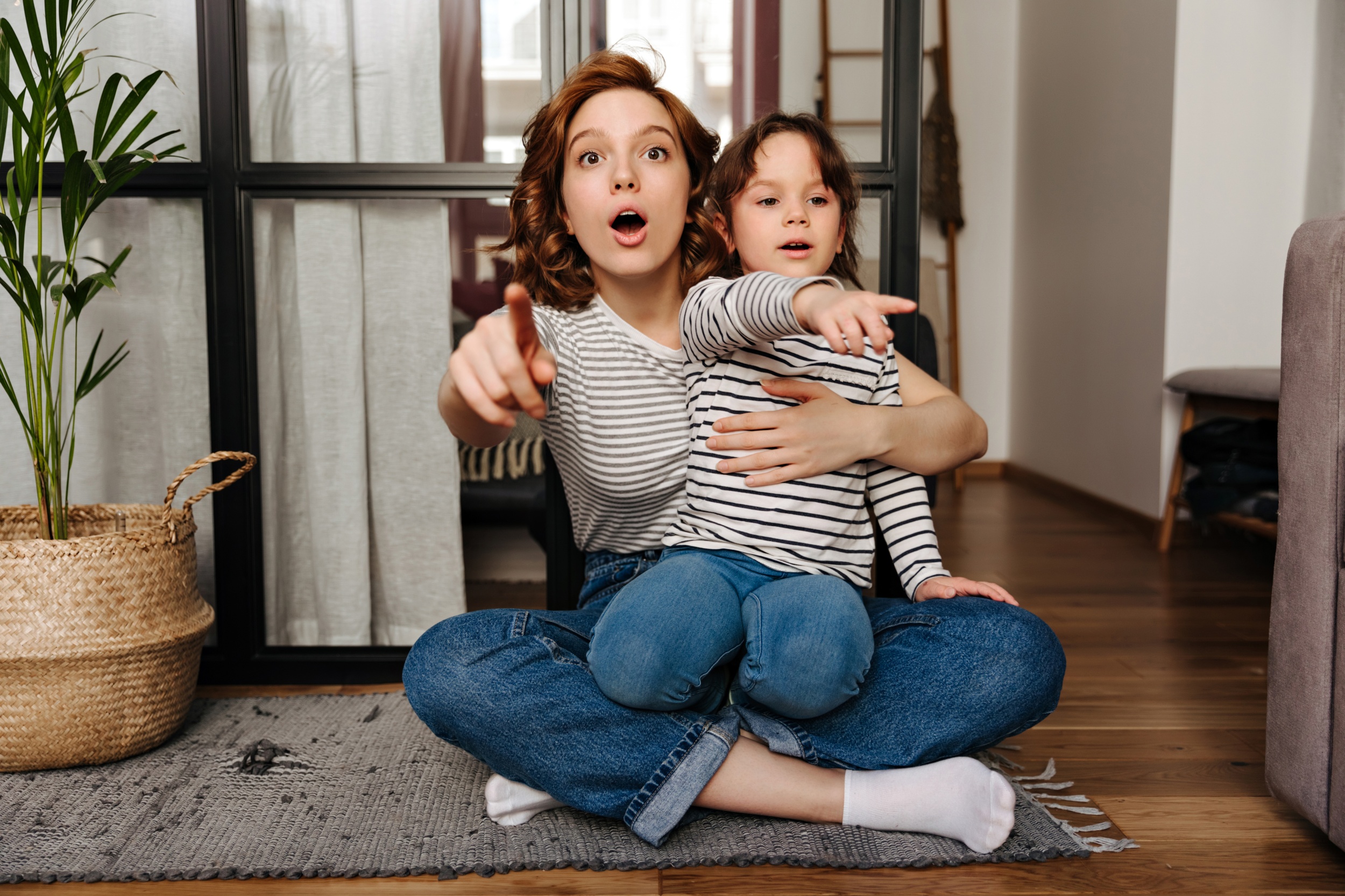 3 mom-daughter-identical-jeans-tshirts-are-looking-camera-surprise-showing-finger.jpg