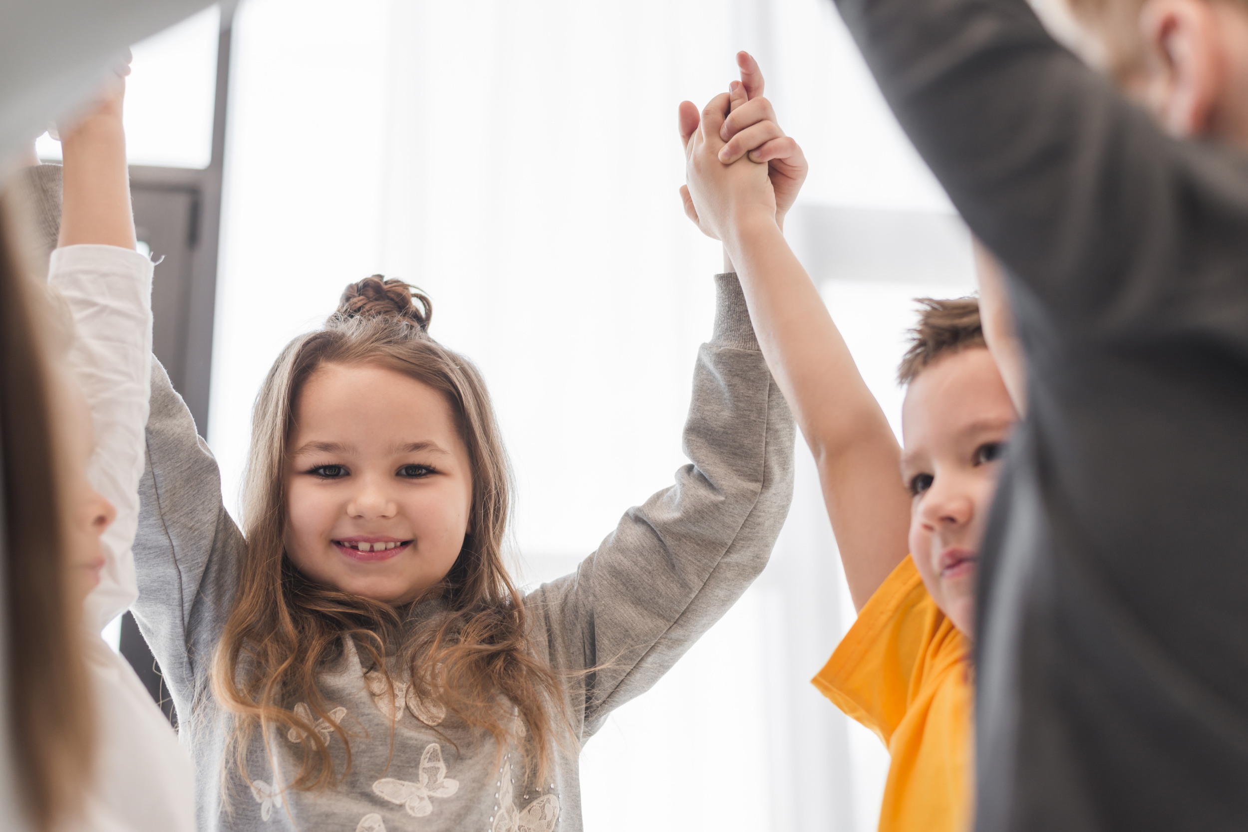 2 children-with-their-hands-up.jpg