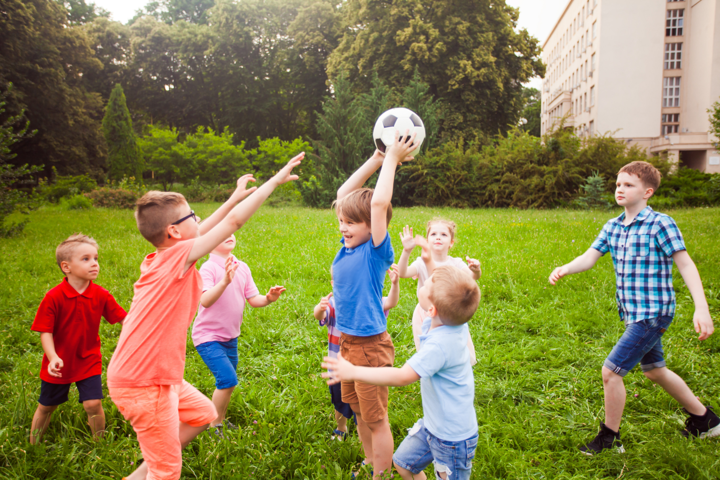 01 funny-kids-are-trying-pick-up-ball-from-each-other-little-boys-girls-are-actively-resting-outdoors.jpg