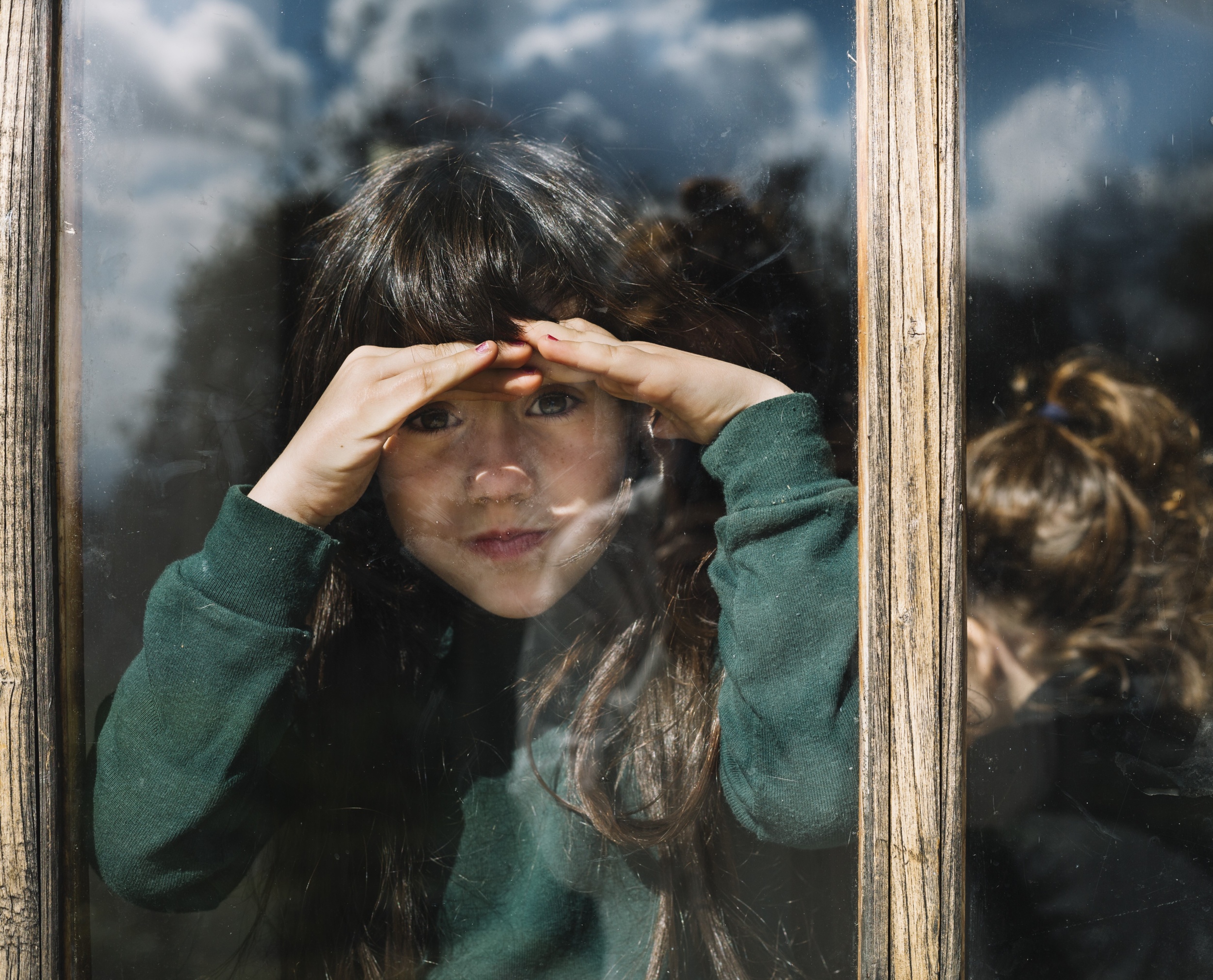 1 girl-shielding-her-eyes-while-looking-through-glass-window.jpg