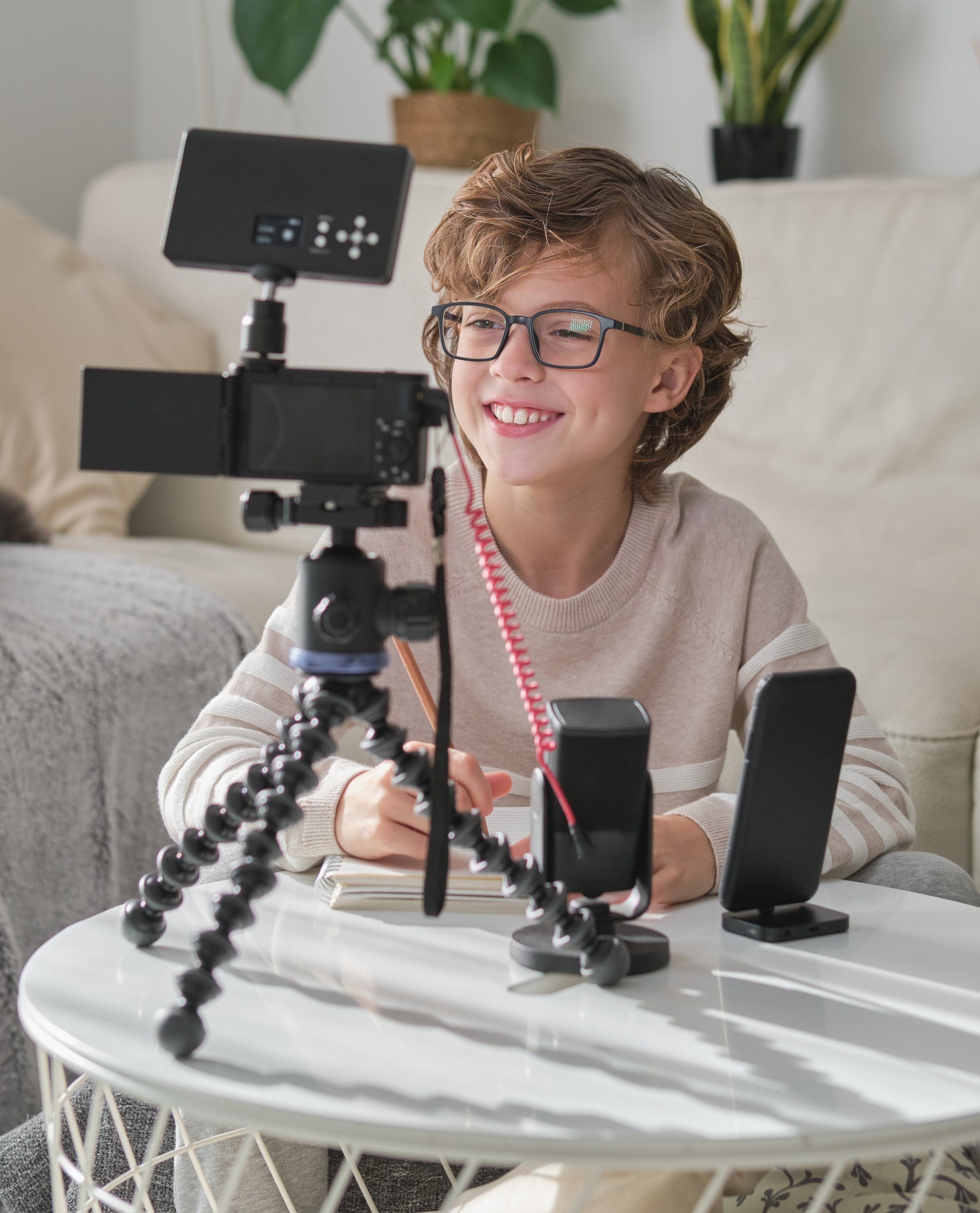 3 delighted-child-process-recording-video-online-blog-while-sitting-white-table-with-camera-tripod-microphone-home.jpg