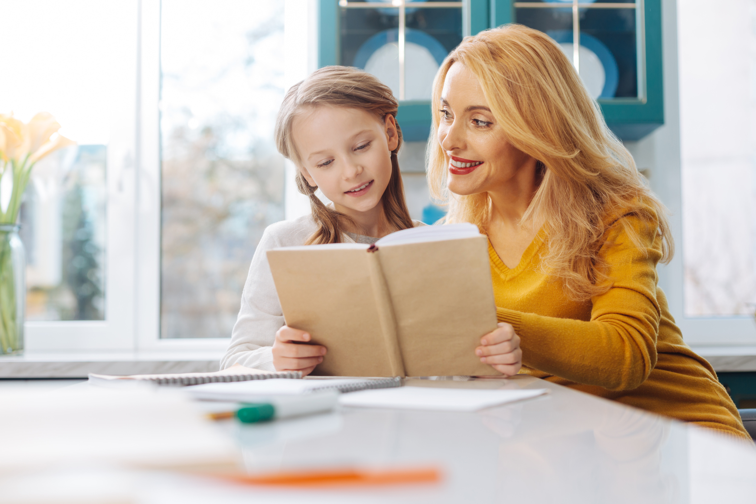 3 beautiful-happy-blond-slim-mother-looking-her-daughter-teaching-her-read-while-sitting-table.jpg